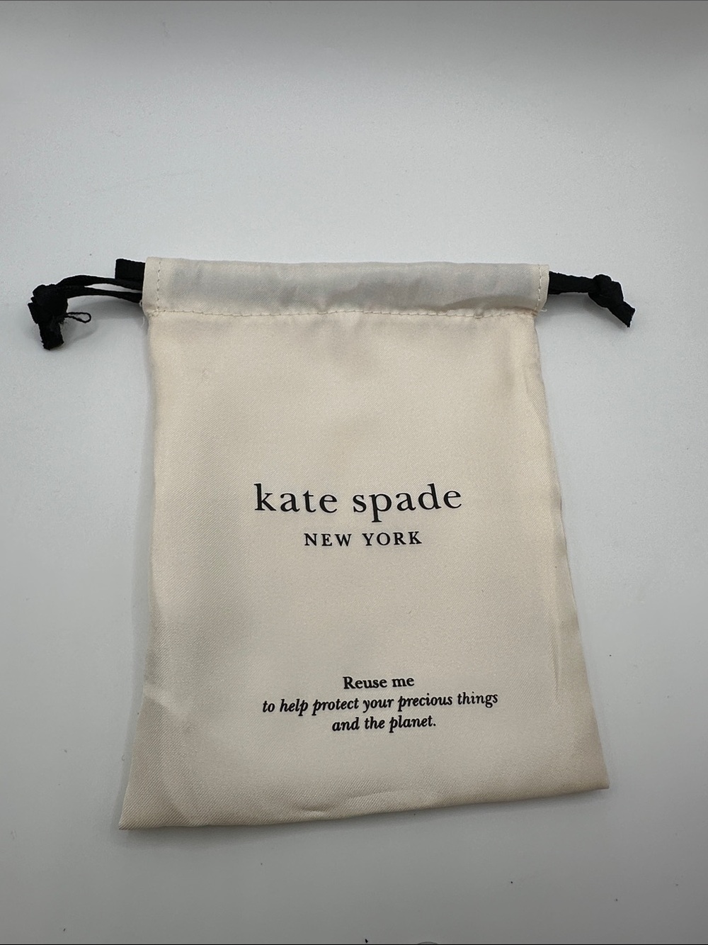 kate spade cream drawstring pouch with black ties